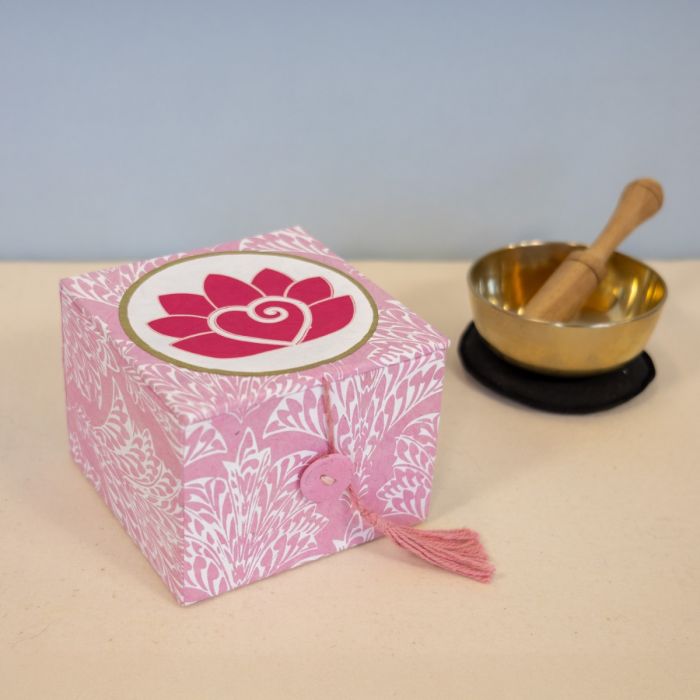 A meditation bowl with a pink gift box