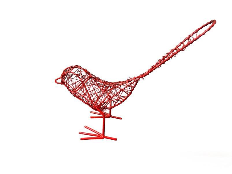 An orange hand made metal wire bird on a white background. 