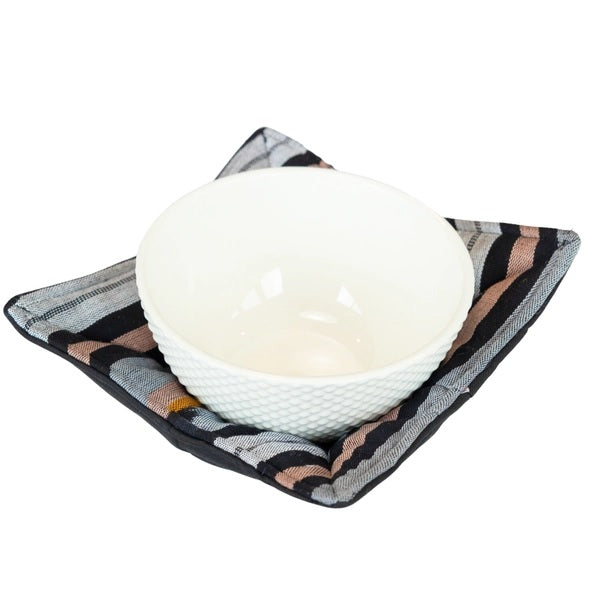 White ceramic bowl on a patterned black and gray bowl cozy