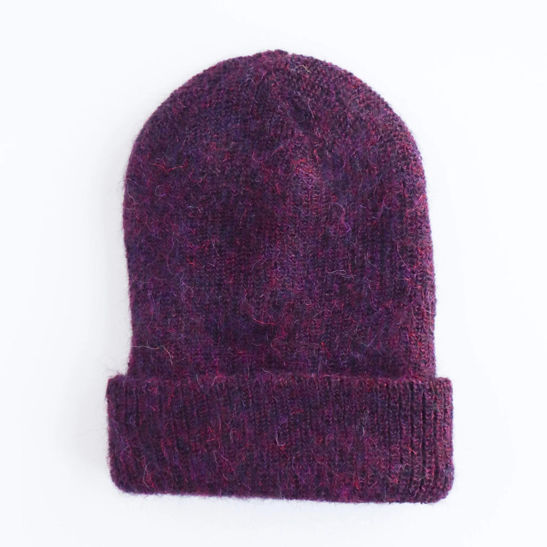 Purple knitted beanie on a white background