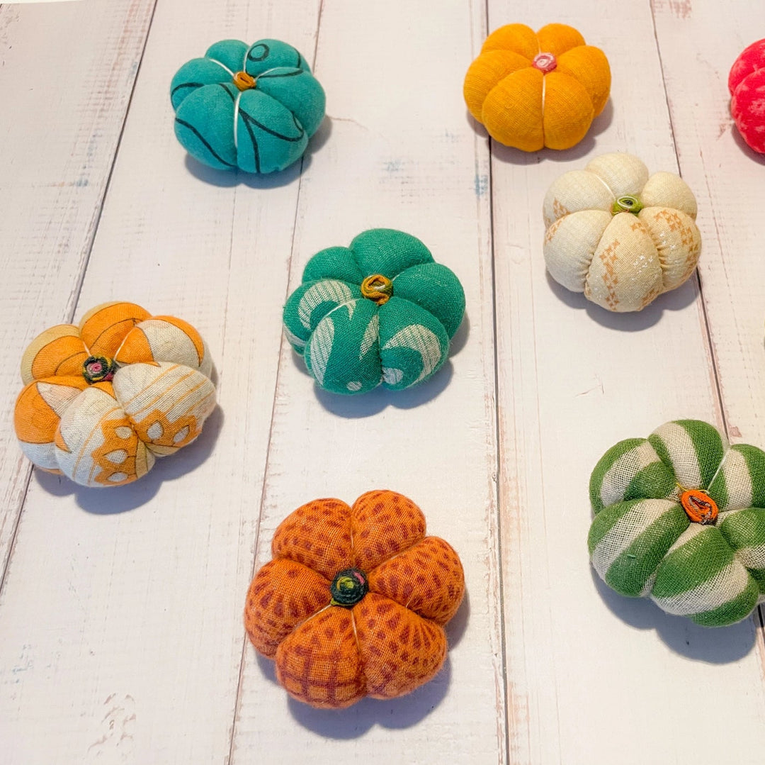 Colorful fabric pumpkins on a wooden surface