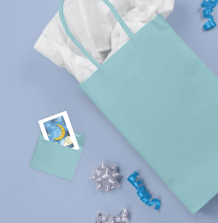 Light blue gift bag on a light purple background with decorative items.