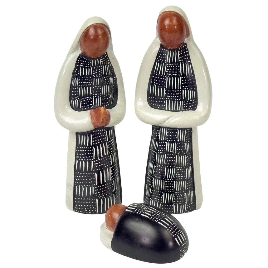 Soapstone nativity scene figures with black and white patterns on a white background