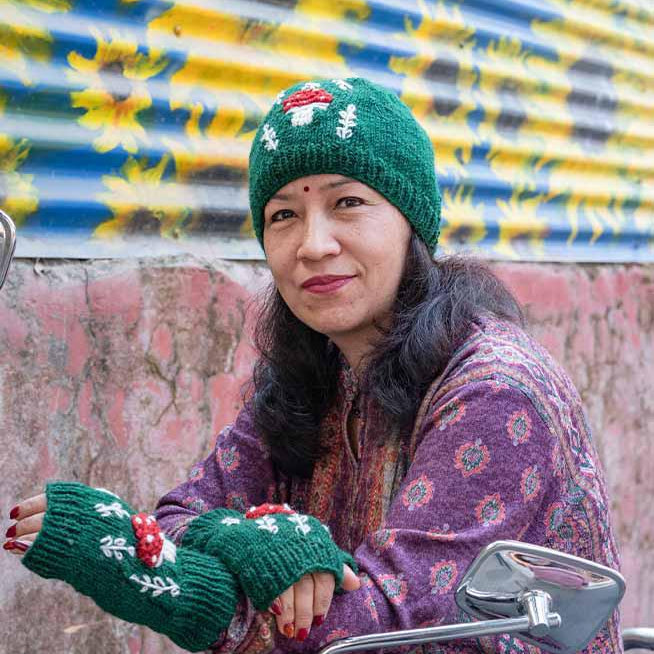 Woman wearing a green knitted hat and gloves with a colorful background