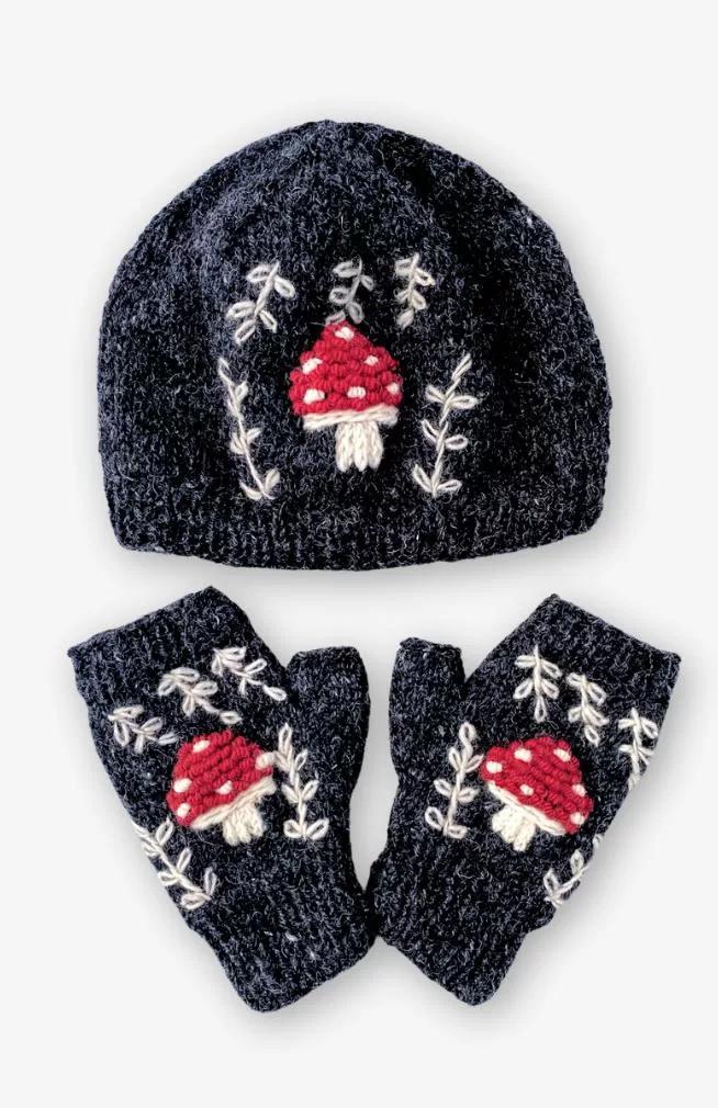 Black knit hat and gloves set with red mushroom design on a white background