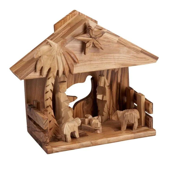 Wooden nativity scene with stable, palm tree, and animals on a white background
