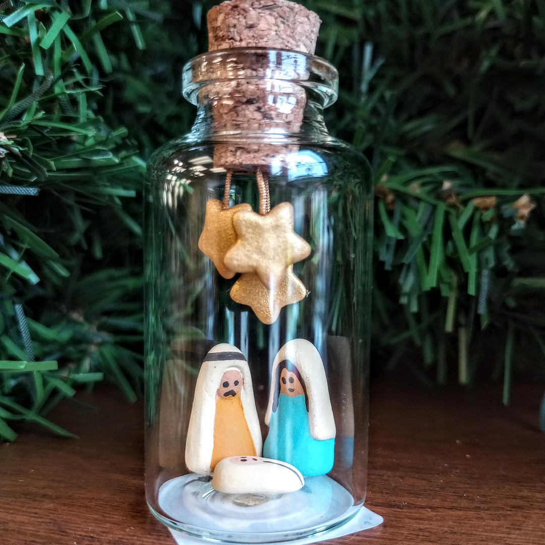 Nativity in a small bottle with christmas tree background
