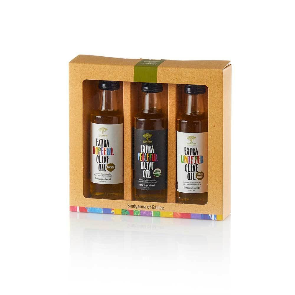 Three bottles of olive oil in a decorative box with colorful labels.