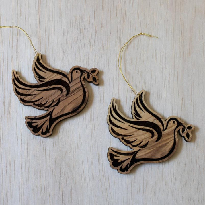 Olive wood dove ornaments on wooden table