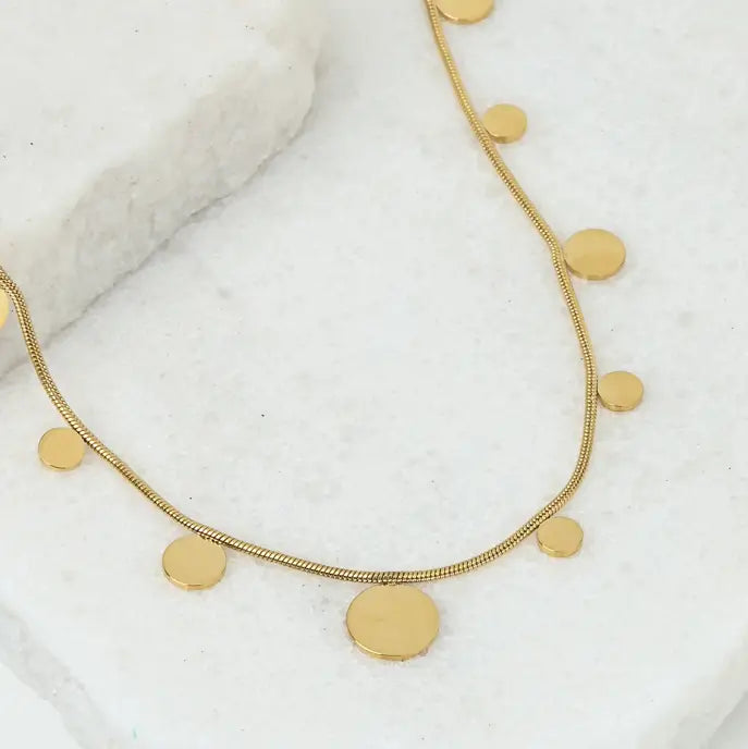 gold plated chain with gold disks on a marble background
