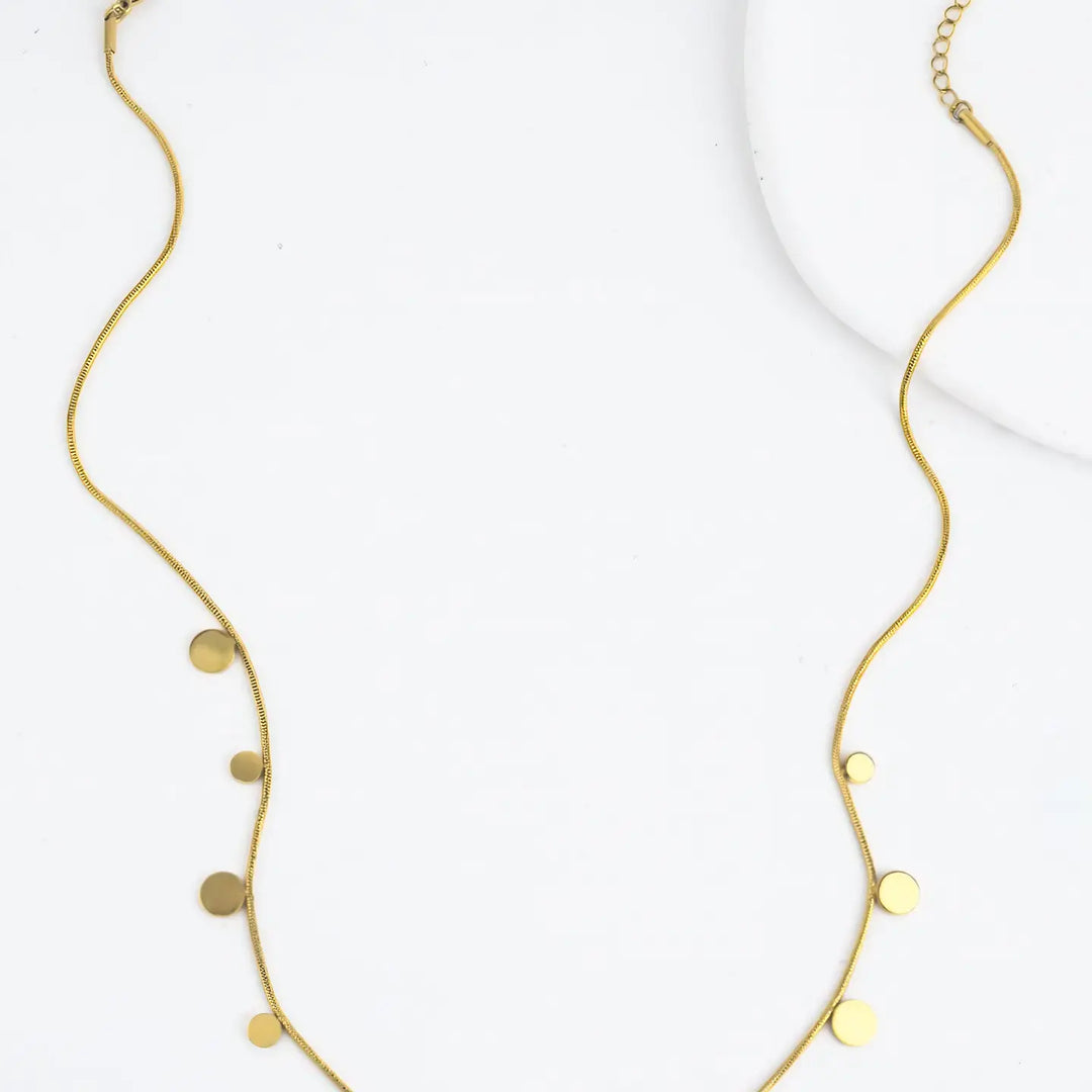 gold plated chain with gold disks on a marble background