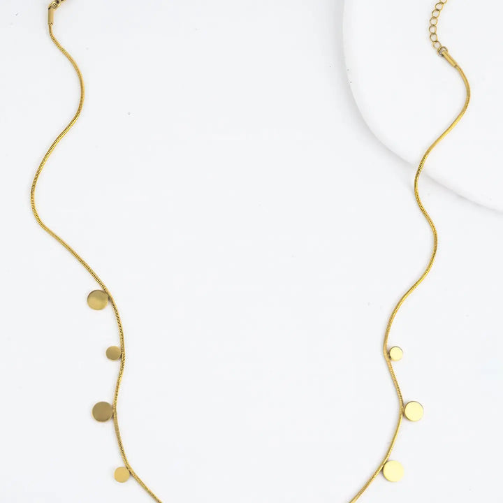 gold plated chain with gold disks on a marble background