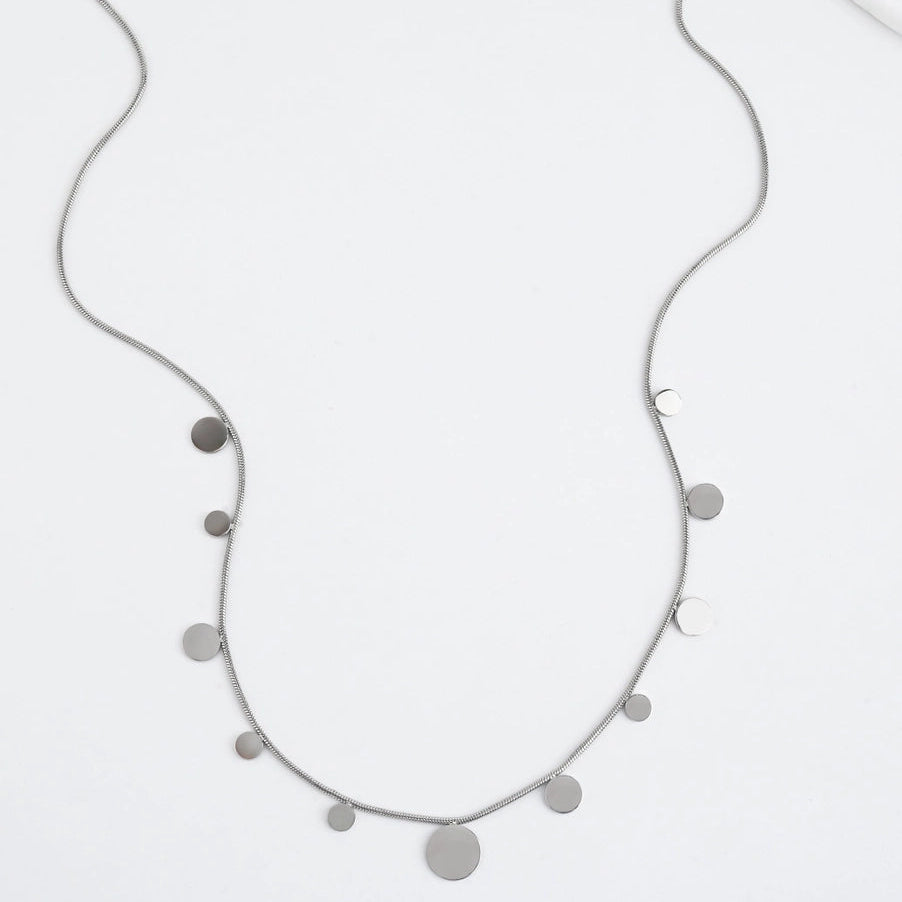 A silver necklace with silver disks on a white background