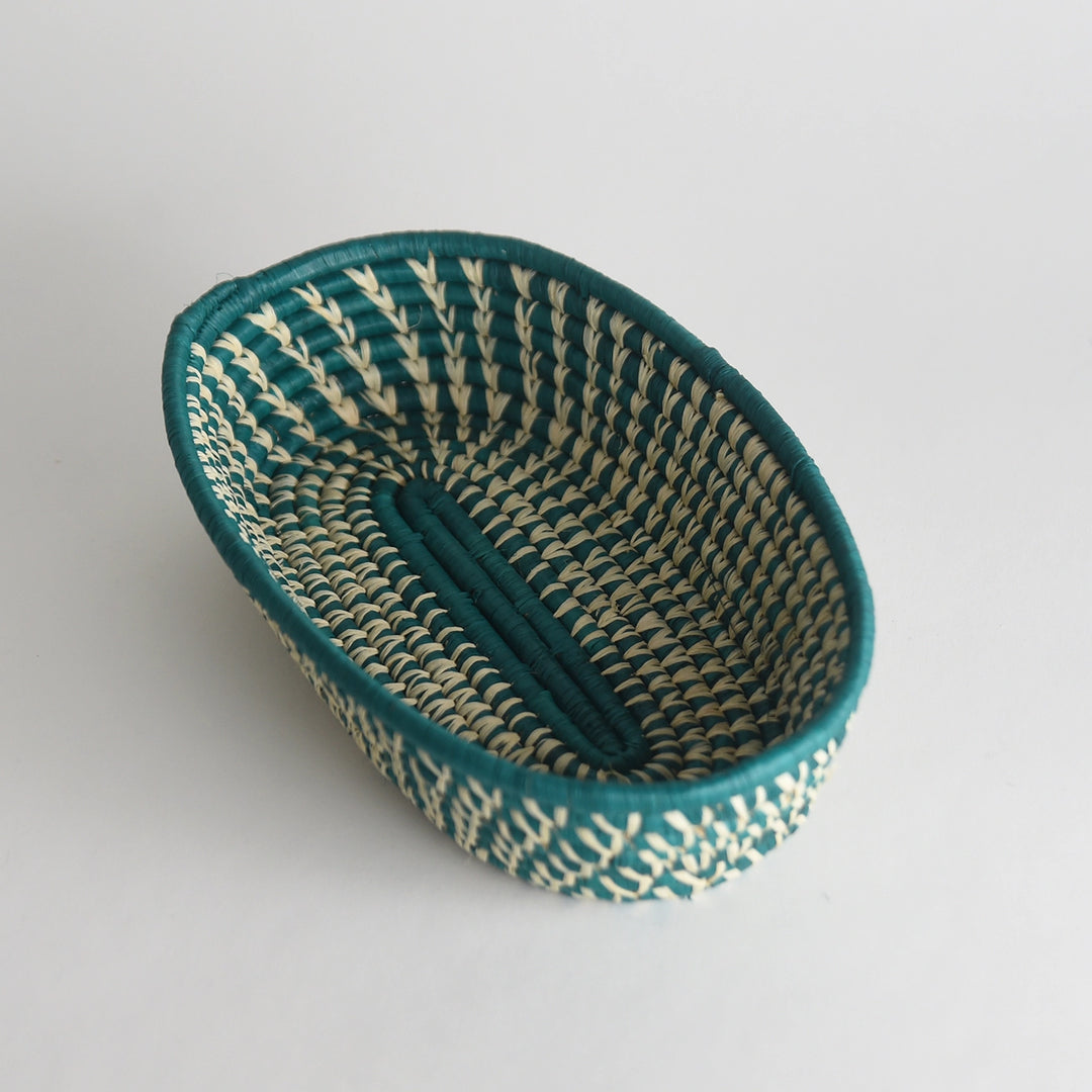 Woven basket with teal and beige pattern on a white background