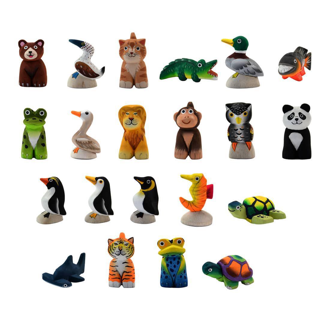 A collection of various hand-carved and painted balsa wood animal figurines, including birds, mammals, and reptiles, positioned against a white background.