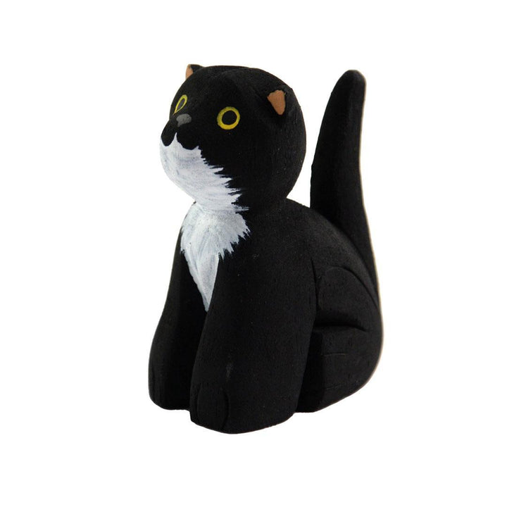 a painted black balsa wood cat on a white background