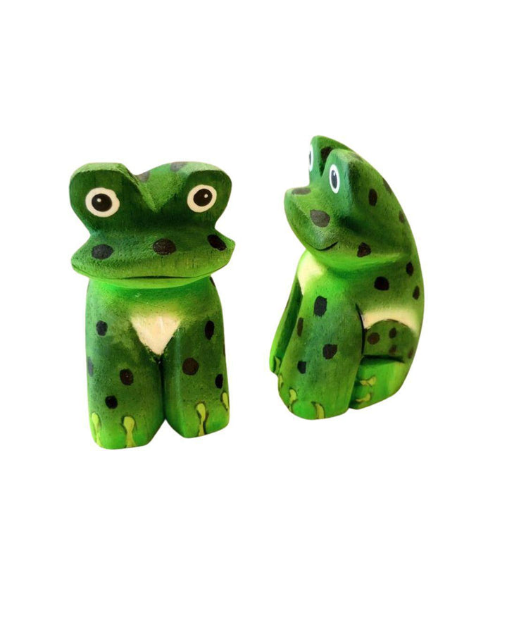 two painted balsa wood frogs on a white background