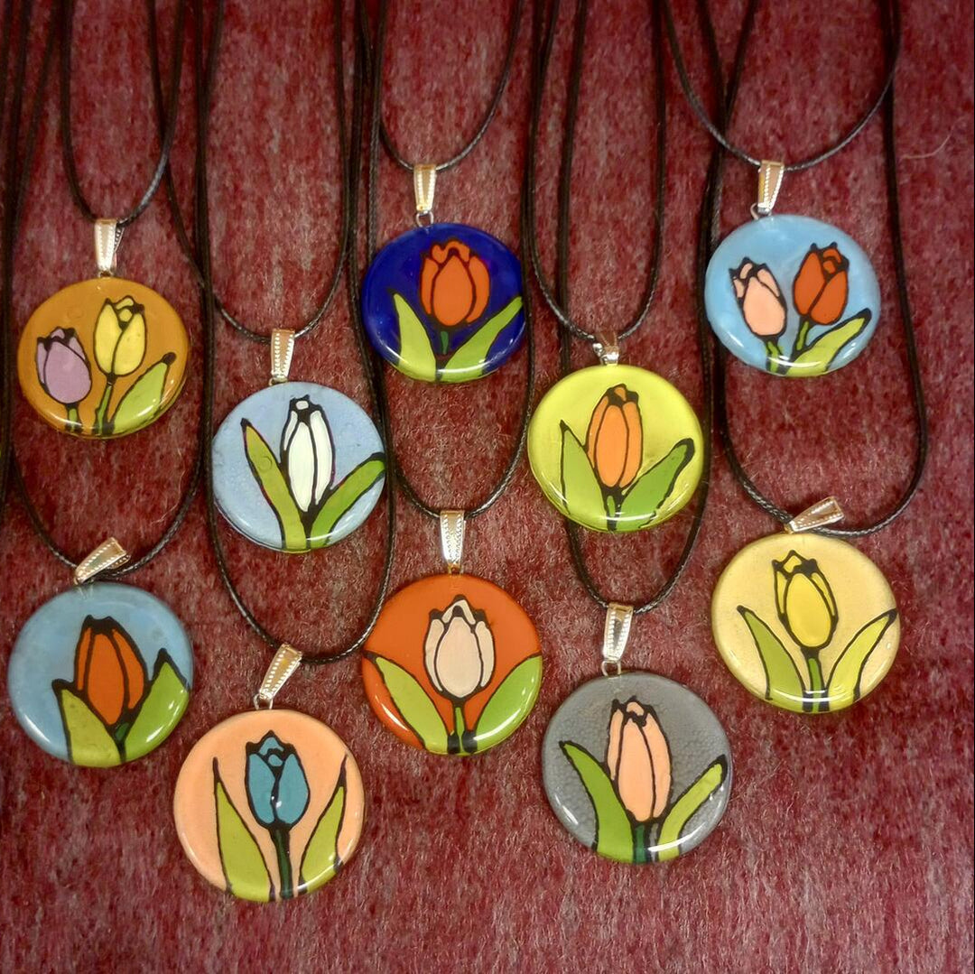 Necklaces with colorful tulip glass pendants on a red background