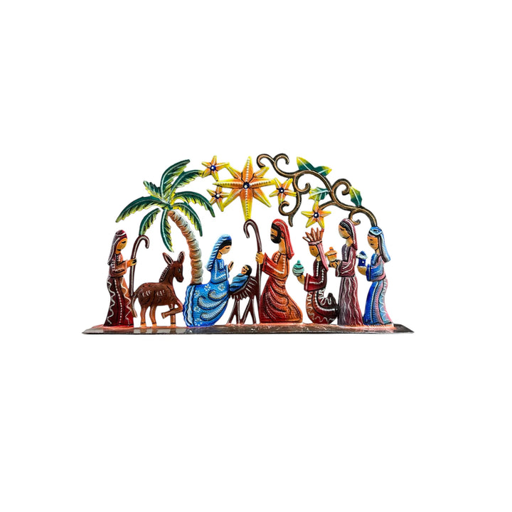 A colorful metal Christmas nativity scene decoration featuring Mary, Joseph, baby Jesus, the three wise men, a donkey, and a palm tree under a starry arch.