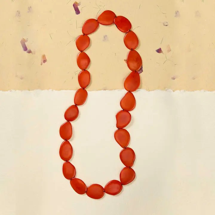 Necklace with tagua red beads on a beige background