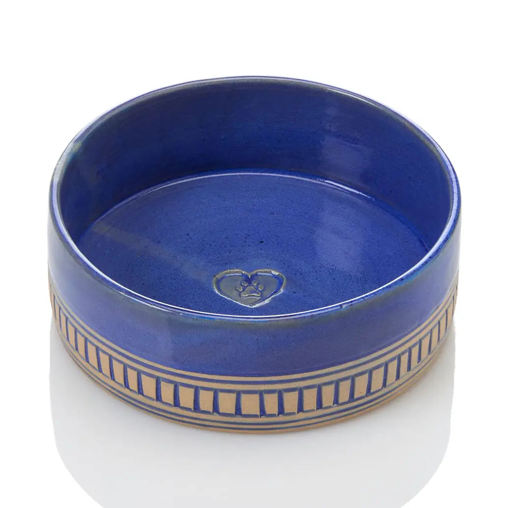 A round ceramic bowl with a glossy cobalt blue glaze and a beige geometric border pattern around the lower rim, shown on a white background.