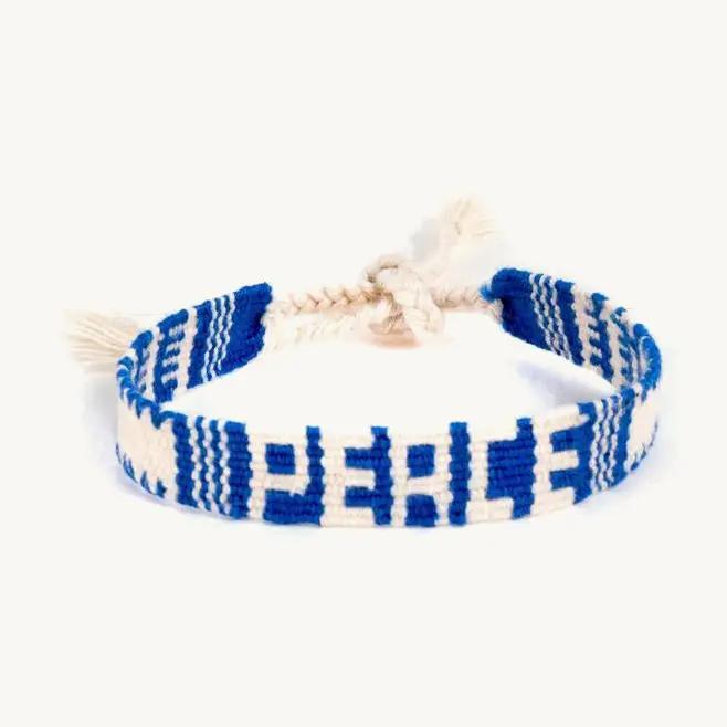Woven bracelet with blue and white pattern spelling "Peace" on a white background