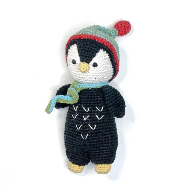 Crocheted penguin toy with a colorful hat and scarf on a white background