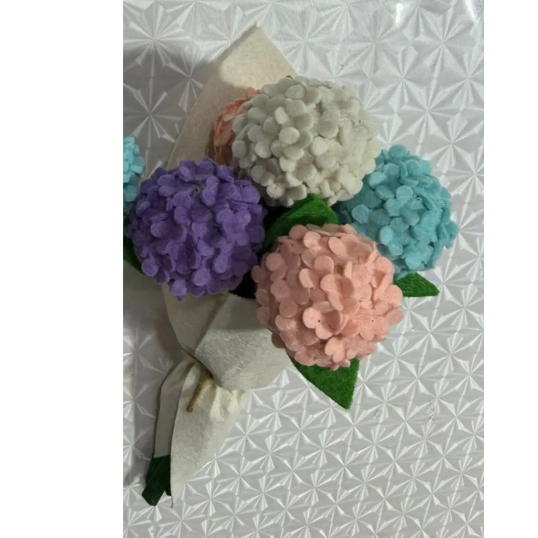 Bouquet of colorful pom-pom flowers on a textured white background