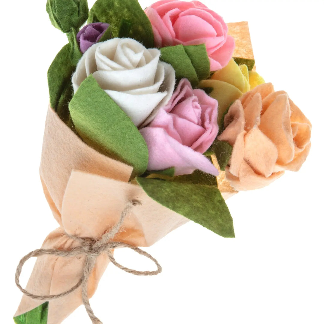 Bouquet of felt flowers in various colors with green leaves on a white background