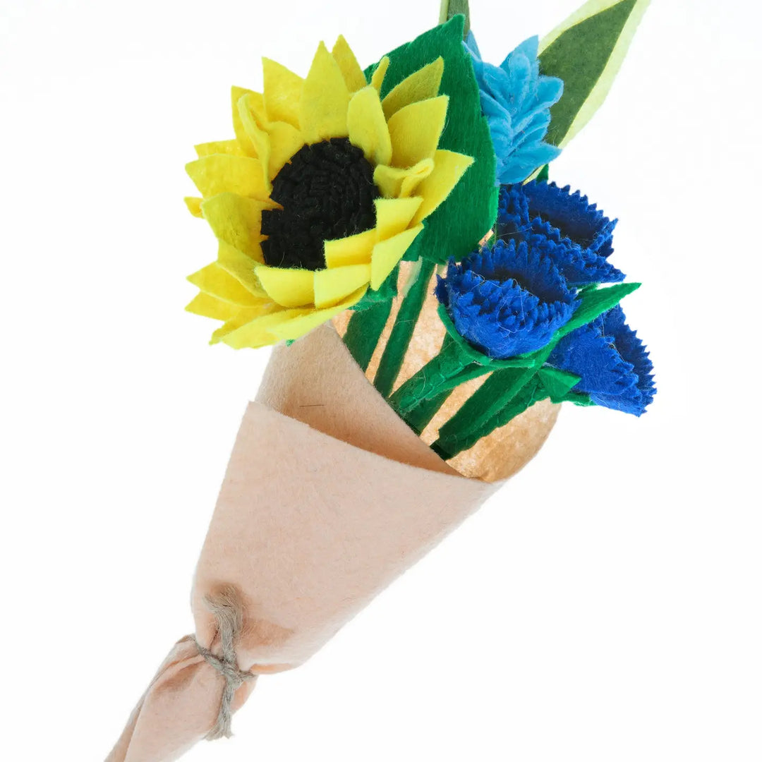 Bouquet of felt sunflowers and blue flowers in a cardboard cone on a white background