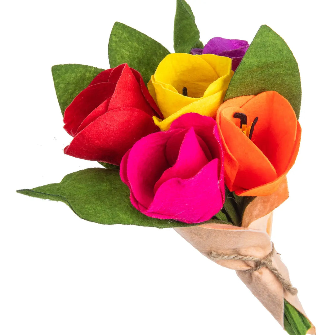 Bouquet of colorful felt flowers with green leaves on a white background