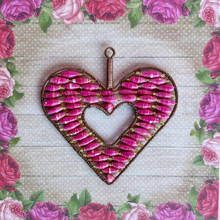 Heart-shaped decorative ornament with pink and gold elements on a floral background