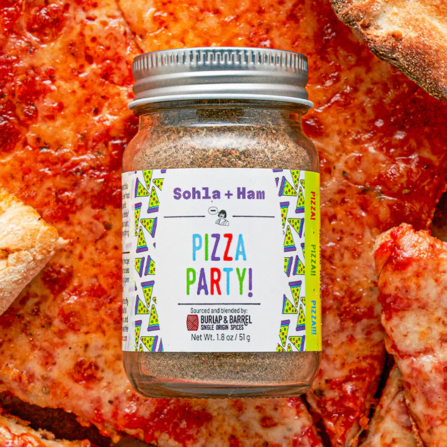 Jar of 'Pizza Party!' seasoning with a pizza in the background