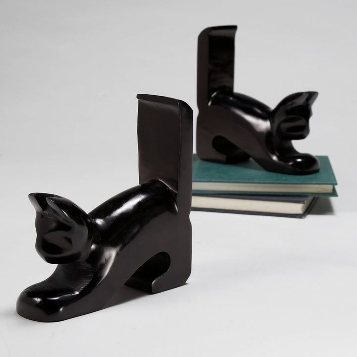 Two glossy black cat-shaped bookends displayed on a light gray background, with one bookend open in the foreground and the other holding a stack of books in the background.
