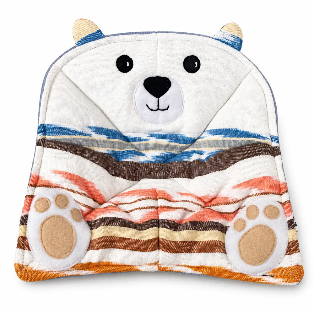 A plush bowl cozy designed like a polar bear, featuring a white bear face with black eyes and nose, blue and brown stripes across the hood, and orange and brown striped patterns on the body, with embroidered paw prints on the feet.