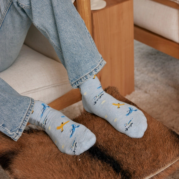 man wearing blue crew socks with songbirds