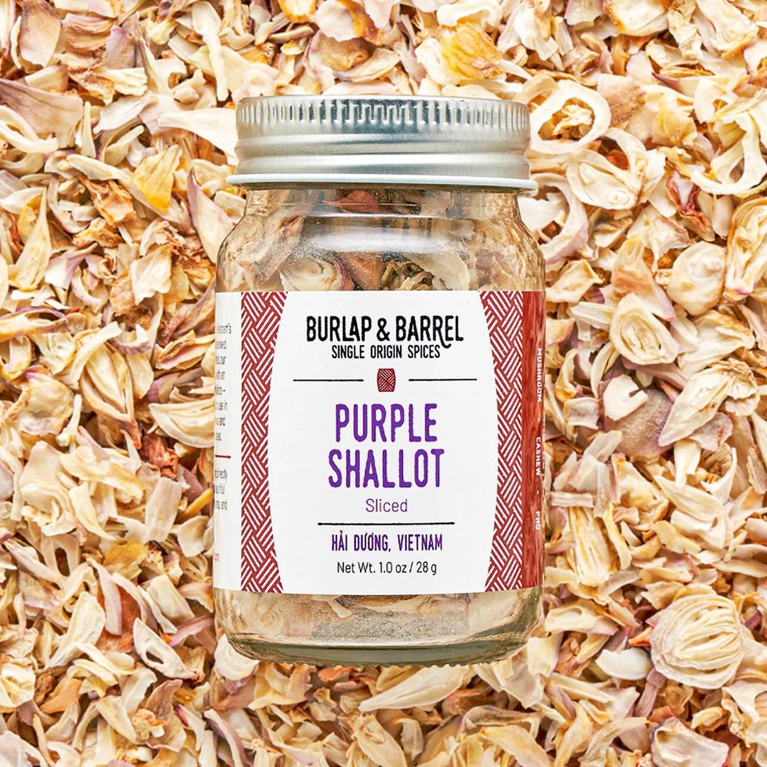 Jar of Burlap & Barrel Purple Shallot spices on a bed of shallots