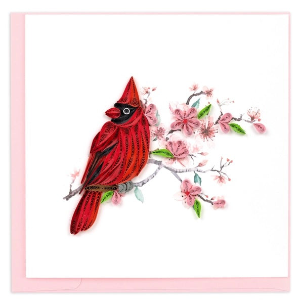 Red cardinal bird on a branch with pink flowers against a white background