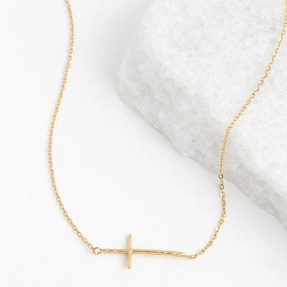 Gold necklace with a small cross pendant on a white background