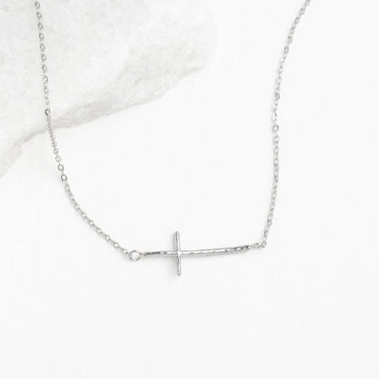 Silver cross necklace on a white background