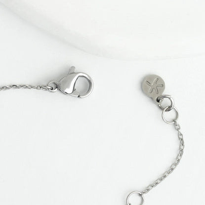 Close-up of a silver necklace with a clasp on a white background
