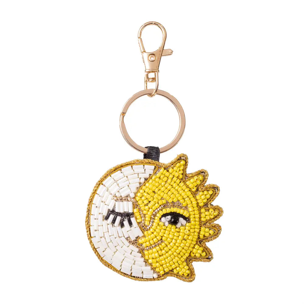 A beaded keychain featuring a split design of a yellow smiling sun and a white moon with closed eyelashes, attached to a gold-tone split ring and lobster clasp.