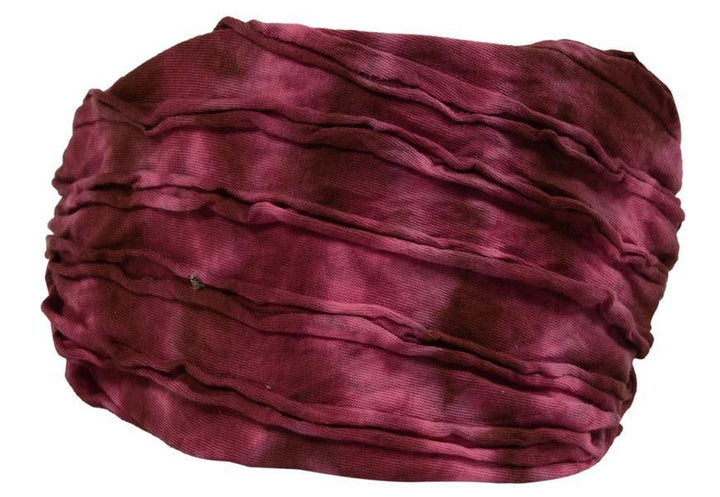 A maroon colored razor cut headband on a white background.