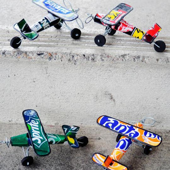 Colorful recycled airplanes sculptures on a concrete surface