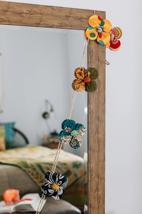 Decorative mirror with colorful flower-shaped garland 