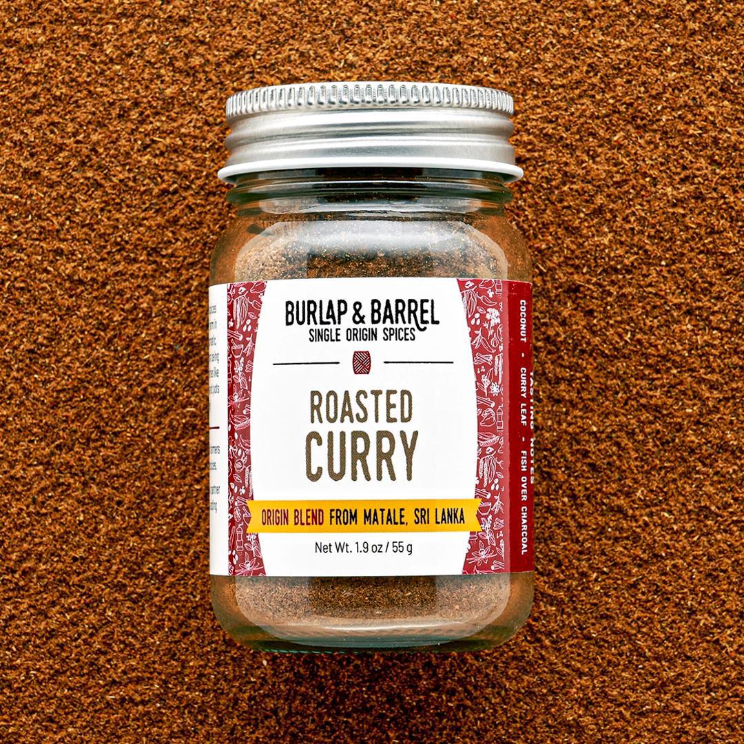 Jar of Burlap & Barrel Roasted Curry spice blend on a brown textured background