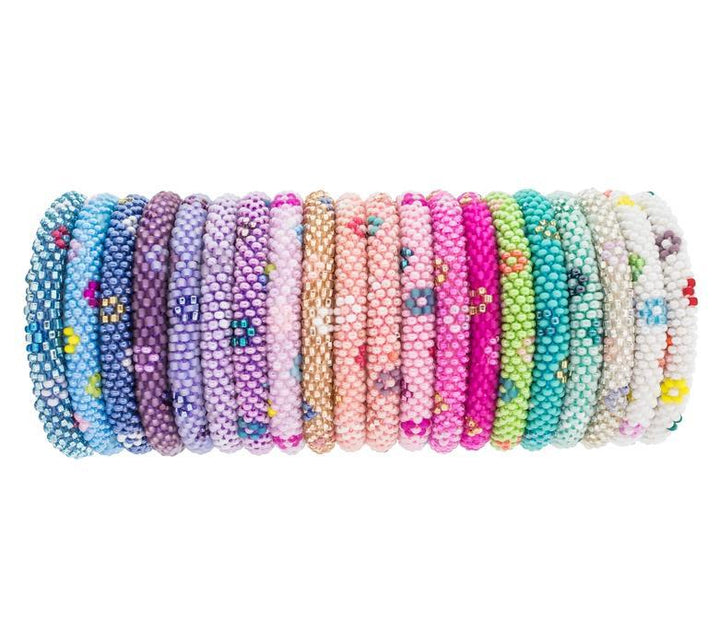A multicolored bracelet made with glass beads and hand-dyed cotton thread, displayed on a roll.