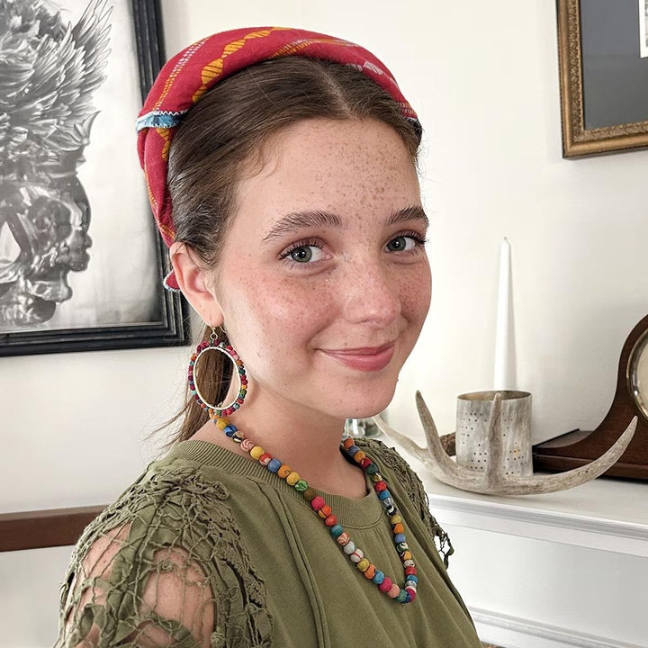 Woman wearing a colorful bandana indoors
