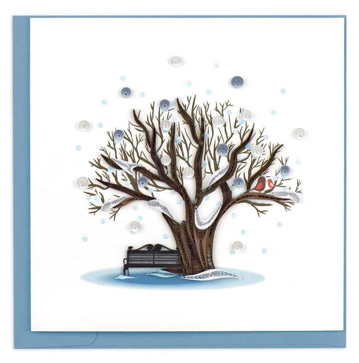A greeting card featuring a quilled design of a tree with snow and birds on it, with a blue envelope.
