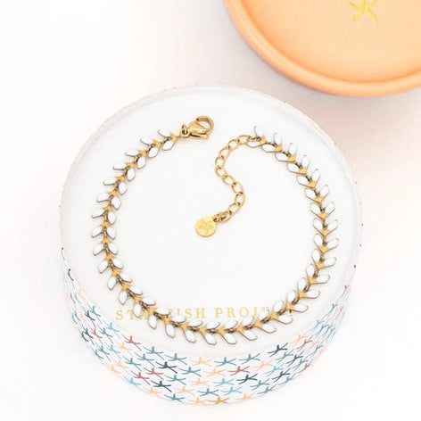 Gold bracelet on a white box with 'Starfish Project' branding in the background